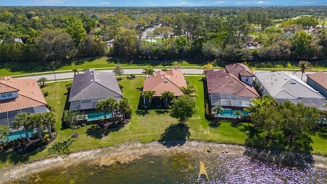 drone / aerial view featuring a residential view and a wooded view