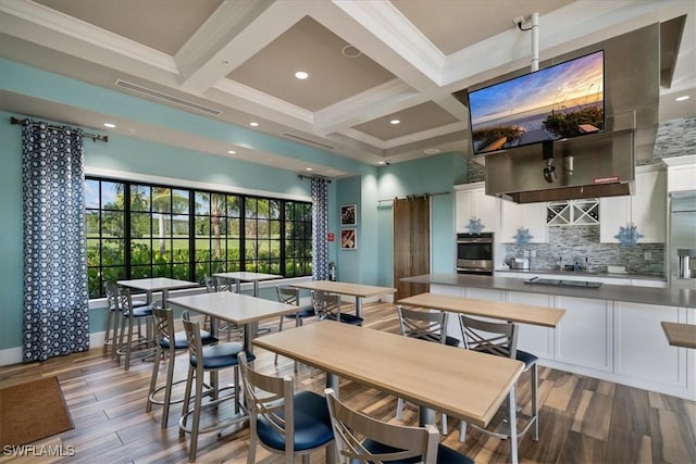 kitchen featuring coffered ceiling, stainless steel oven, white cabinets, tasteful backsplash, and beamed ceiling