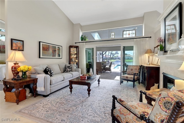 tiled living room with a glass covered fireplace and a towering ceiling