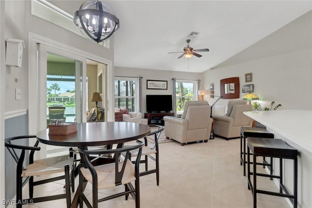 dining room featuring ceiling fan with notable chandelier, lofted ceiling, visible vents, and light tile patterned floors