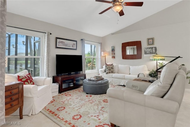 living room with a ceiling fan, vaulted ceiling, and tile patterned floors