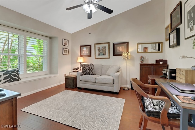 interior space with lofted ceiling, a ceiling fan, baseboards, and wood finished floors