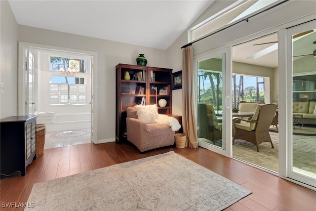 living area with lofted ceiling, ceiling fan, and wood finished floors