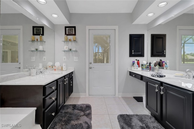 full bath with two vanities, tile patterned flooring, a sink, and baseboards