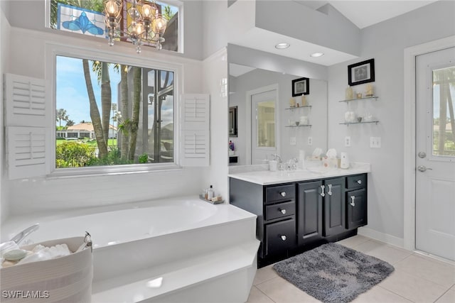 full bath featuring a garden tub, vanity, a chandelier, baseboards, and tile patterned floors