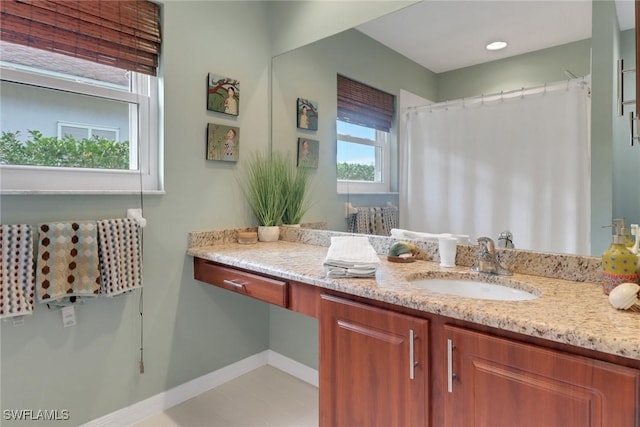 full bathroom with a shower with shower curtain, baseboards, and vanity