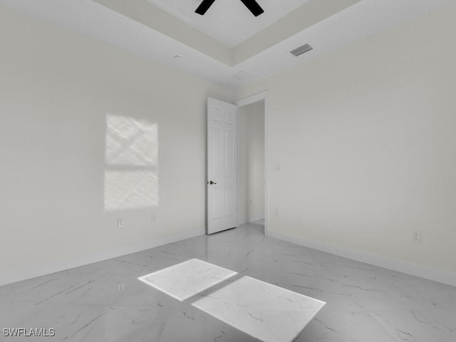 unfurnished room featuring visible vents, baseboards, marble finish floor, and a raised ceiling