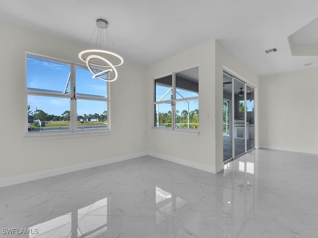 unfurnished dining area featuring plenty of natural light, marble finish floor, visible vents, and baseboards