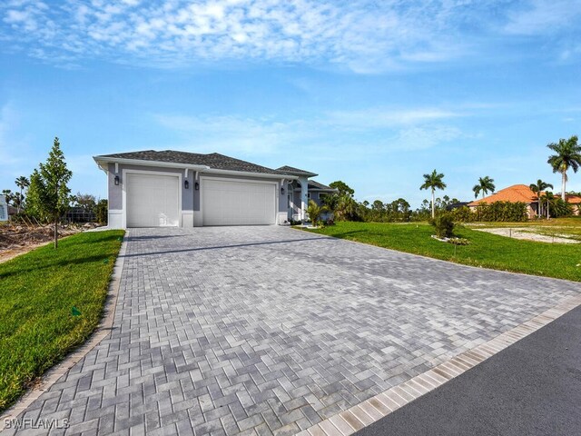 view of front of home with decorative driveway, an attached garage, a front yard, and stucco siding