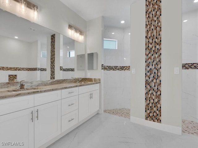 bathroom with marble finish floor, a marble finish shower, and a sink