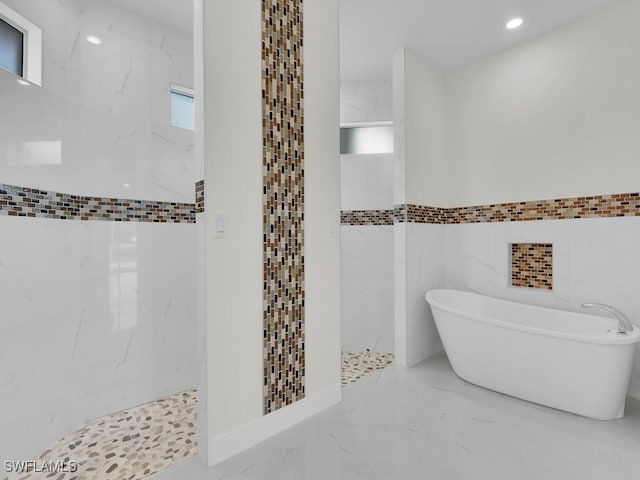 full bath with a marble finish shower, recessed lighting, a freestanding tub, marble finish floor, and tile walls