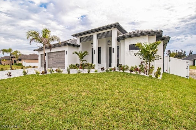 view of front facade with concrete driveway, an attached garage, fence, a front yard, and stucco siding