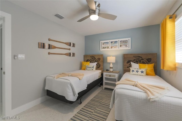 carpeted bedroom featuring ceiling fan, visible vents, and baseboards