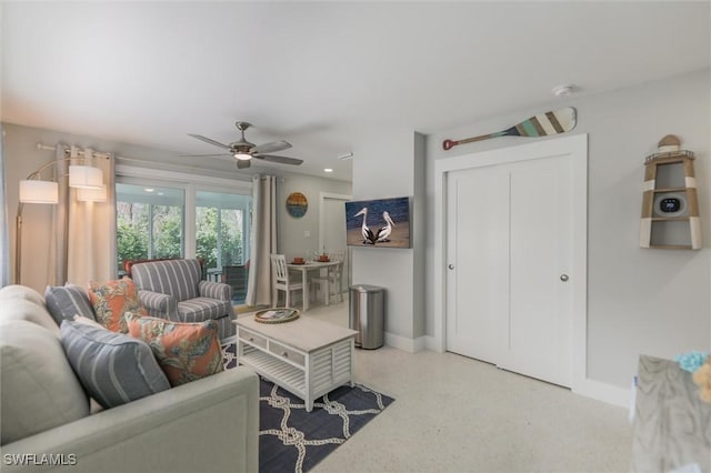 living room with ceiling fan and baseboards