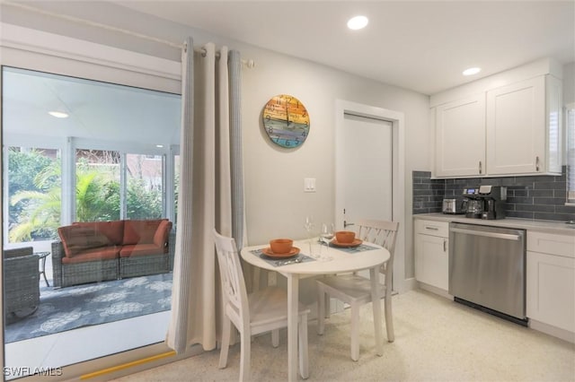 kitchen with decorative backsplash, white cabinets, light countertops, stainless steel dishwasher, and recessed lighting