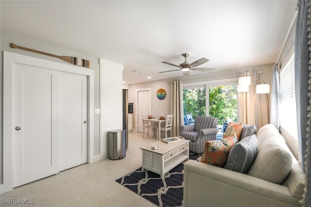 living area with recessed lighting, ceiling fan, and speckled floor