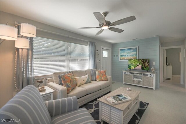 carpeted living area with a ceiling fan