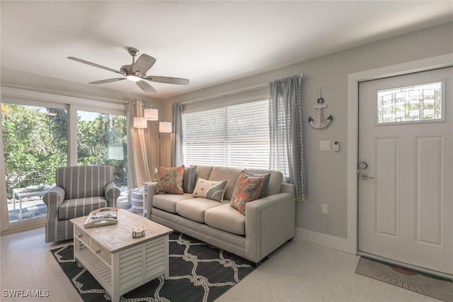 living area featuring a ceiling fan, a wealth of natural light, and baseboards