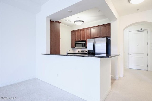 23159 Amgci Way Unit 3108, Estero, FL 33928 - kitchen with appliances with stainless steel finishes, light carpet, a peninsula, arched walkways, and baseboards