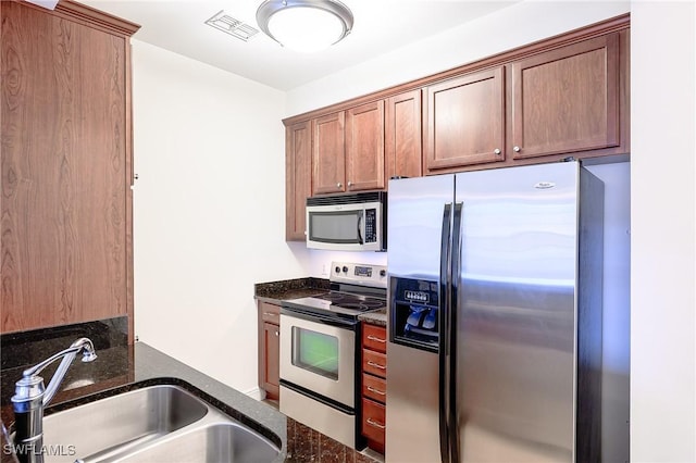 23159 Amgci Way Unit 3108, Estero, FL 33928 - kitchen featuring appliances with stainless steel finishes, a sink, and dark stone countertops