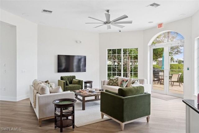 living room featuring ceiling fan, light wood-style flooring, and visible vents