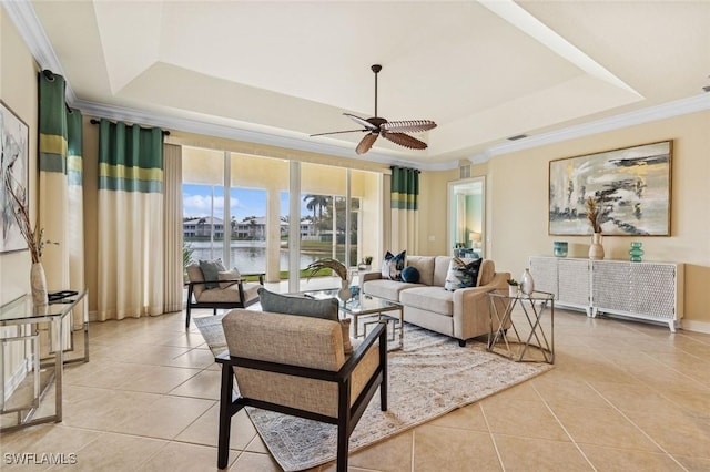 living area with ceiling fan, light tile patterned flooring, a raised ceiling, and crown molding