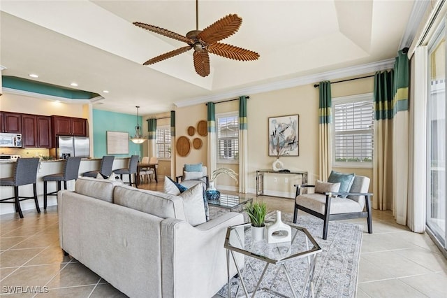 living area with a tray ceiling, ceiling fan, recessed lighting, and light tile patterned floors