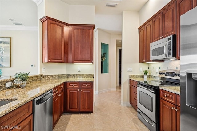 kitchen with light tile patterned floors, visible vents, light stone counters, stainless steel appliances, and crown molding