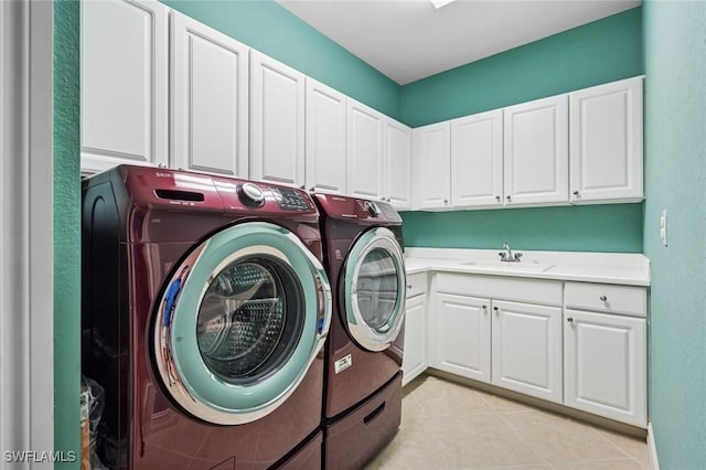 laundry area with light tile patterned floors, cabinet space, a sink, and independent washer and dryer