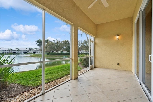 unfurnished sunroom featuring a water view and ceiling fan