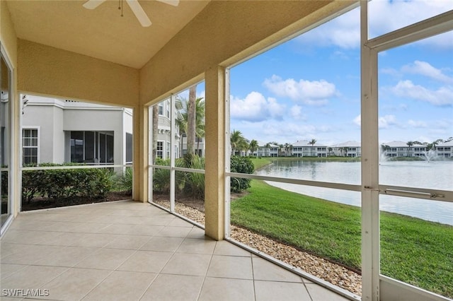 unfurnished sunroom featuring lofted ceiling, a water view, and ceiling fan