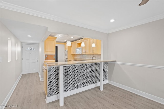 kitchen featuring white appliances, baseboards, decorative backsplash, light wood-style floors, and light brown cabinets