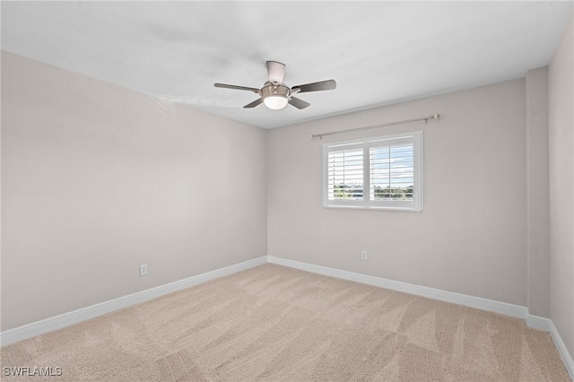 spare room featuring carpet, a ceiling fan, and baseboards