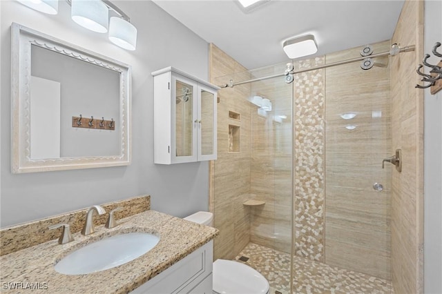 bathroom featuring a stall shower, vanity, and toilet