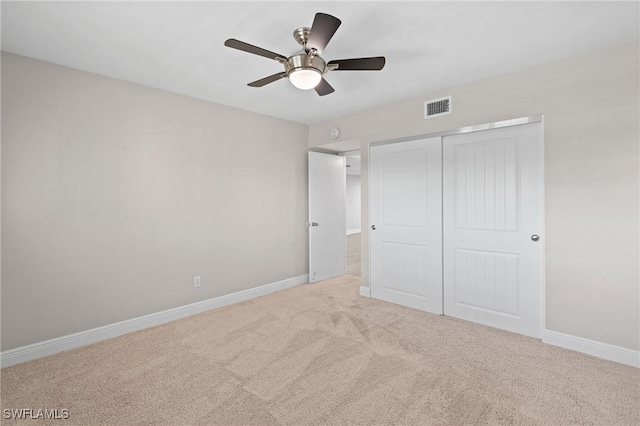 unfurnished bedroom with a closet, carpet flooring, visible vents, and baseboards