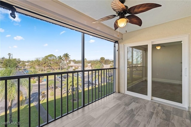 unfurnished sunroom with ceiling fan