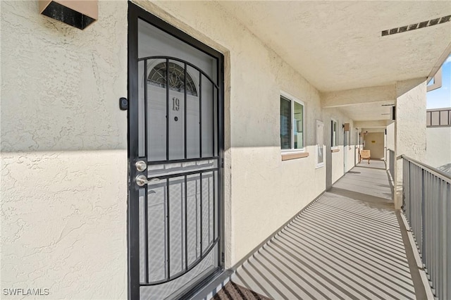 doorway to property featuring a balcony and stucco siding