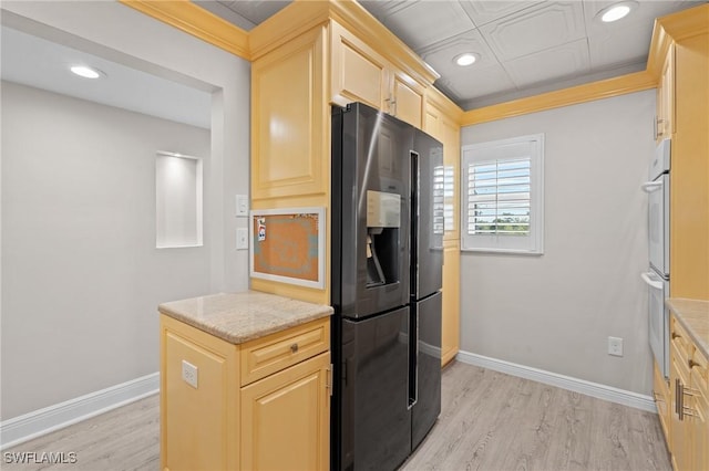 kitchen featuring baseboards, light brown cabinetry, black fridge with ice dispenser, and light wood-style floors