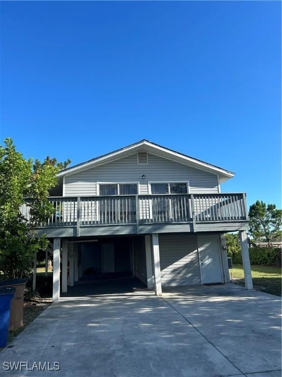 view of front facade with a deck, a carport, and driveway