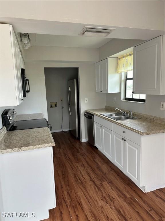 kitchen featuring white cabinets, stainless steel appliances, and a sink