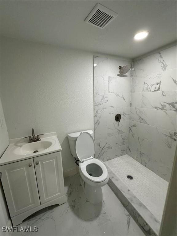 full bathroom with a stall shower, visible vents, vanity, and toilet