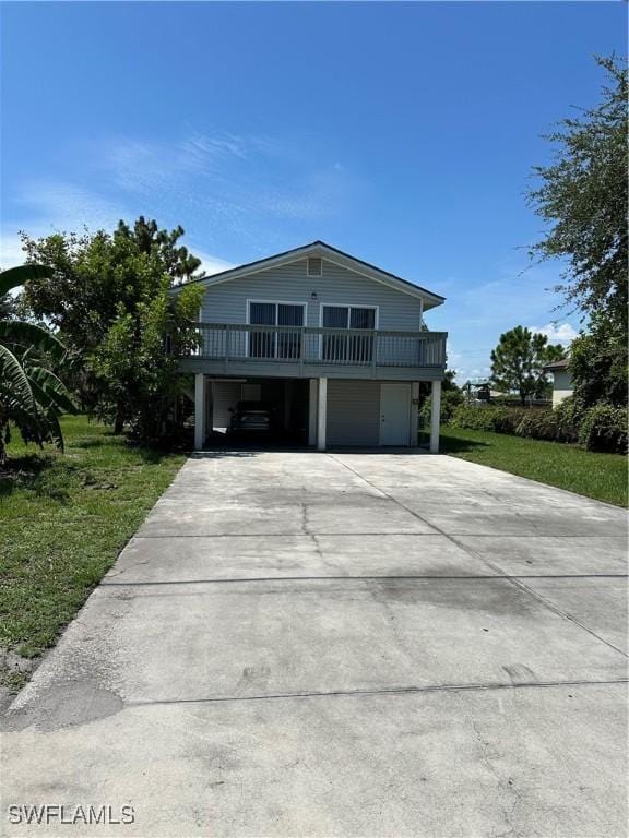 view of front of property with a carport, driveway, and a front lawn