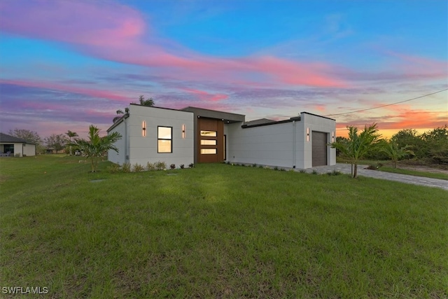 modern home with driveway, a lawn, and an attached garage