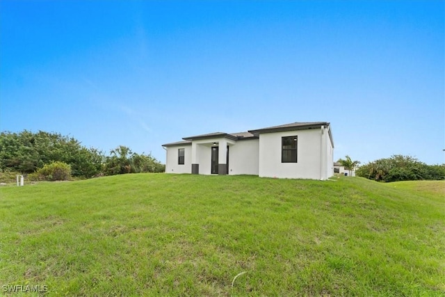 rear view of house featuring a yard