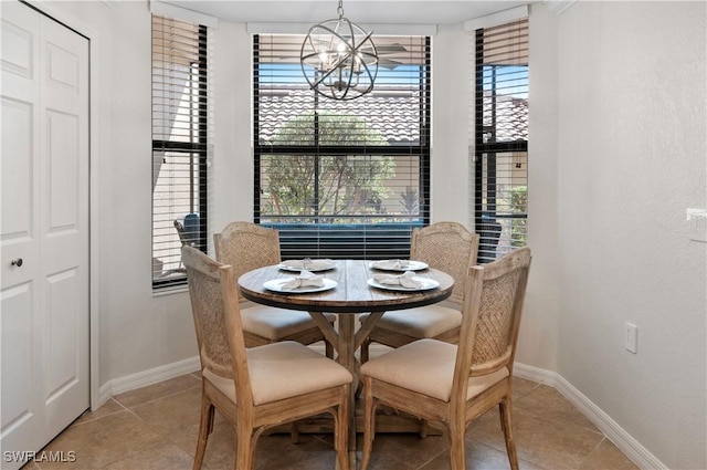 dining area featuring baseboards, light tile patterned floors, and a notable chandelier