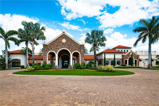 view of front facade featuring decorative driveway and a front yard