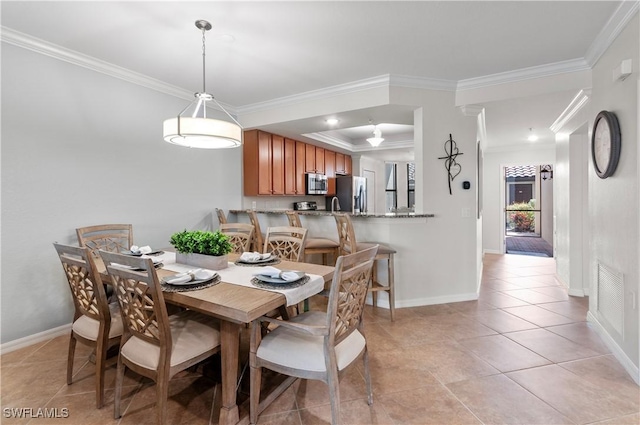 dining space featuring crown molding, baseboards, and light tile patterned floors