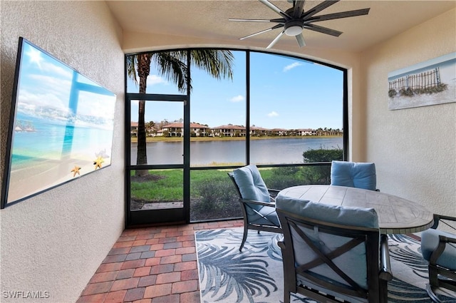 sunroom / solarium with a water view and ceiling fan