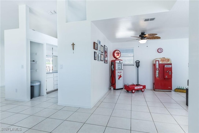 interior space with light tile patterned floors, visible vents, a healthy amount of sunlight, and a ceiling fan