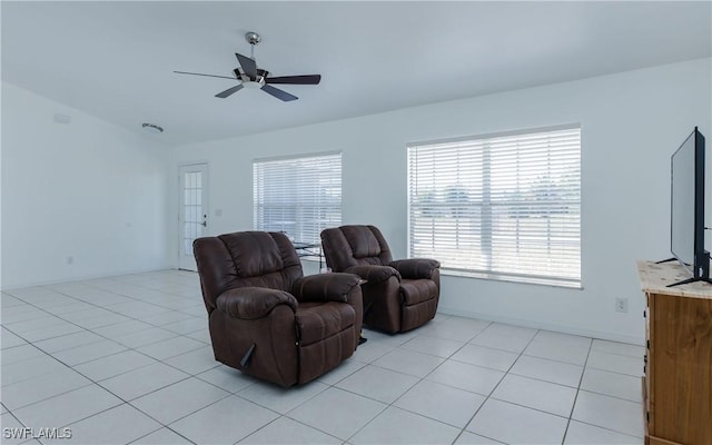 living room featuring baseboards, ceiling fan, and light tile patterned flooring